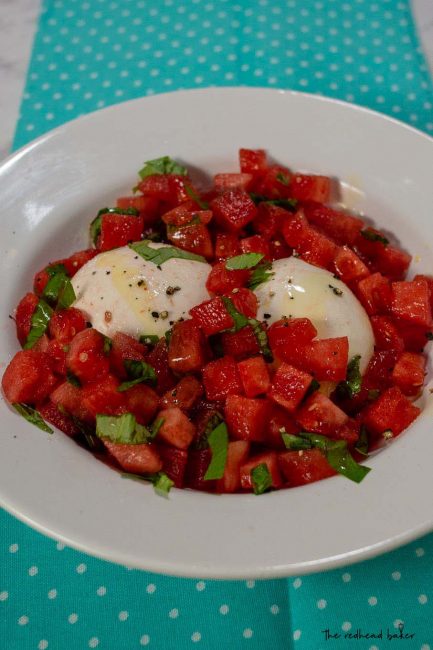 A dish of watermelon burrata salad on a blue towel