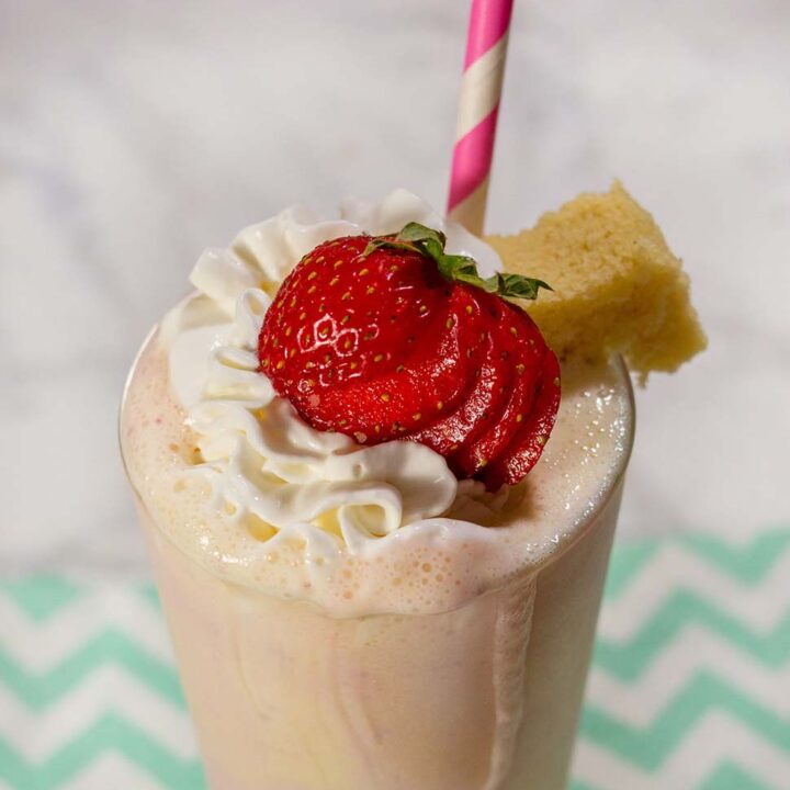 close up shot of strawberry milkshake with whipped cream In a