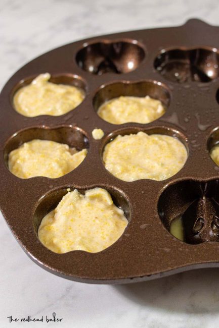 Apple cornbread batter portioned into Nordwicware's apple cakelet pan