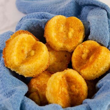 Apple cornbread cakelets in a blue-towel-lined basket