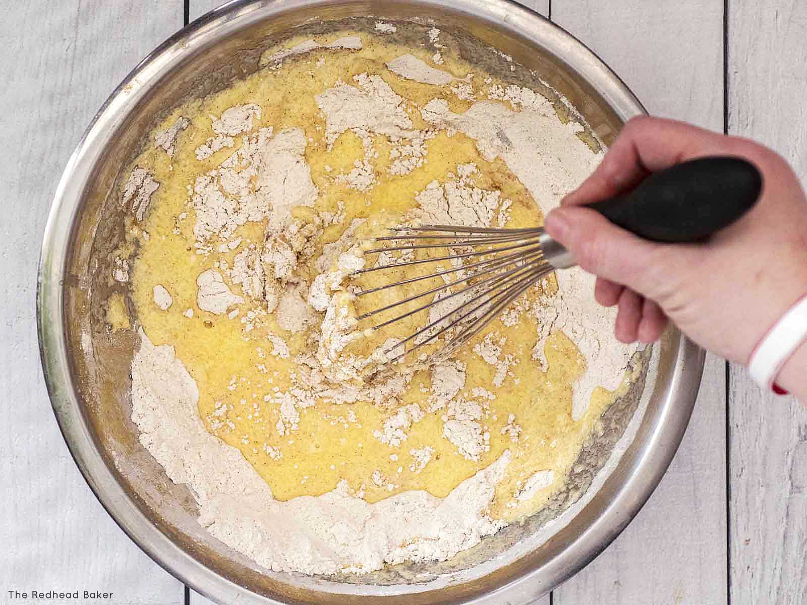 Mixing the wet and dry ingredients with a whisk.