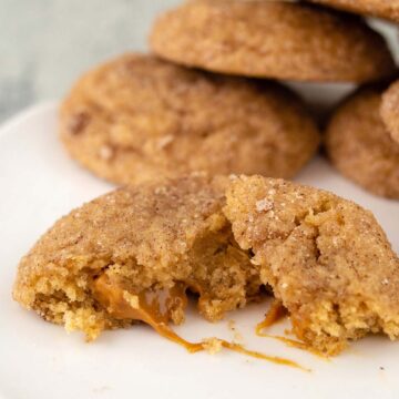 Half of a caramel-stuffed apple butter snickerdoodle with the caramel center oozing out