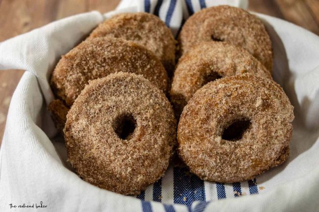 Six cider doughnuts in a round dish.