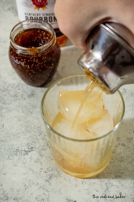 Honey-fig whiskey sour being poured into a glass