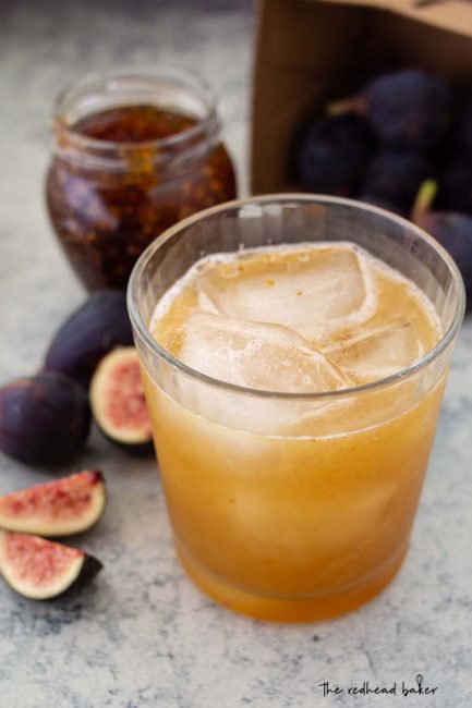 Honey-fig whiskey sour in front of a jar of fig spread and fresh figs