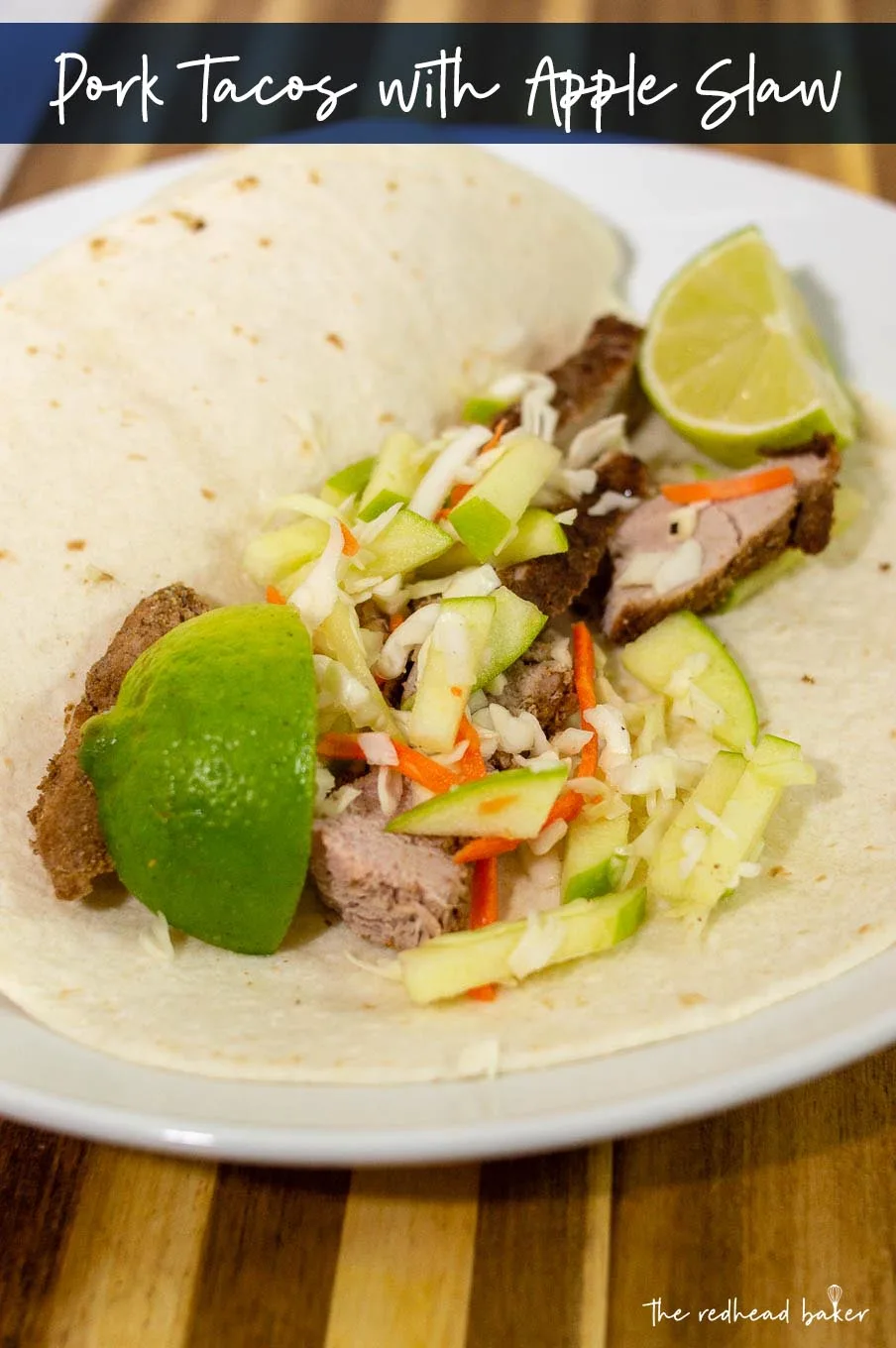 Pork tacos with apple slaw on a plate with lime wedges