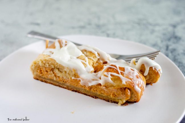 A slice of pumpkin cheesecake danish braid on a white plate.