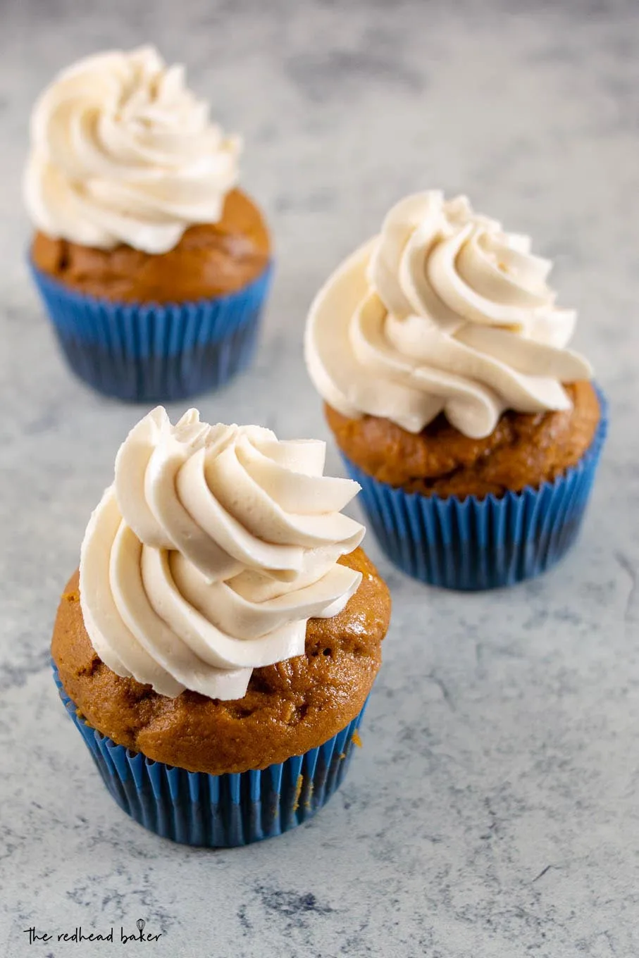 An overhead shot of three pumpkin cupcakes