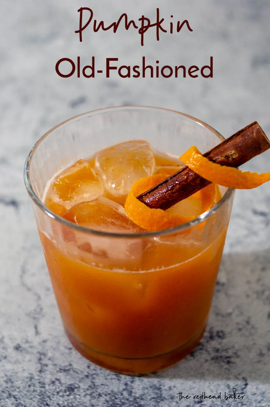 A pumpkin old-fashioned garnished an orange peel twist and a cinnamon stick