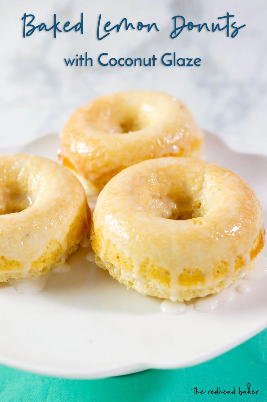 A close-up of three baked lemon donuts with coconut glaze