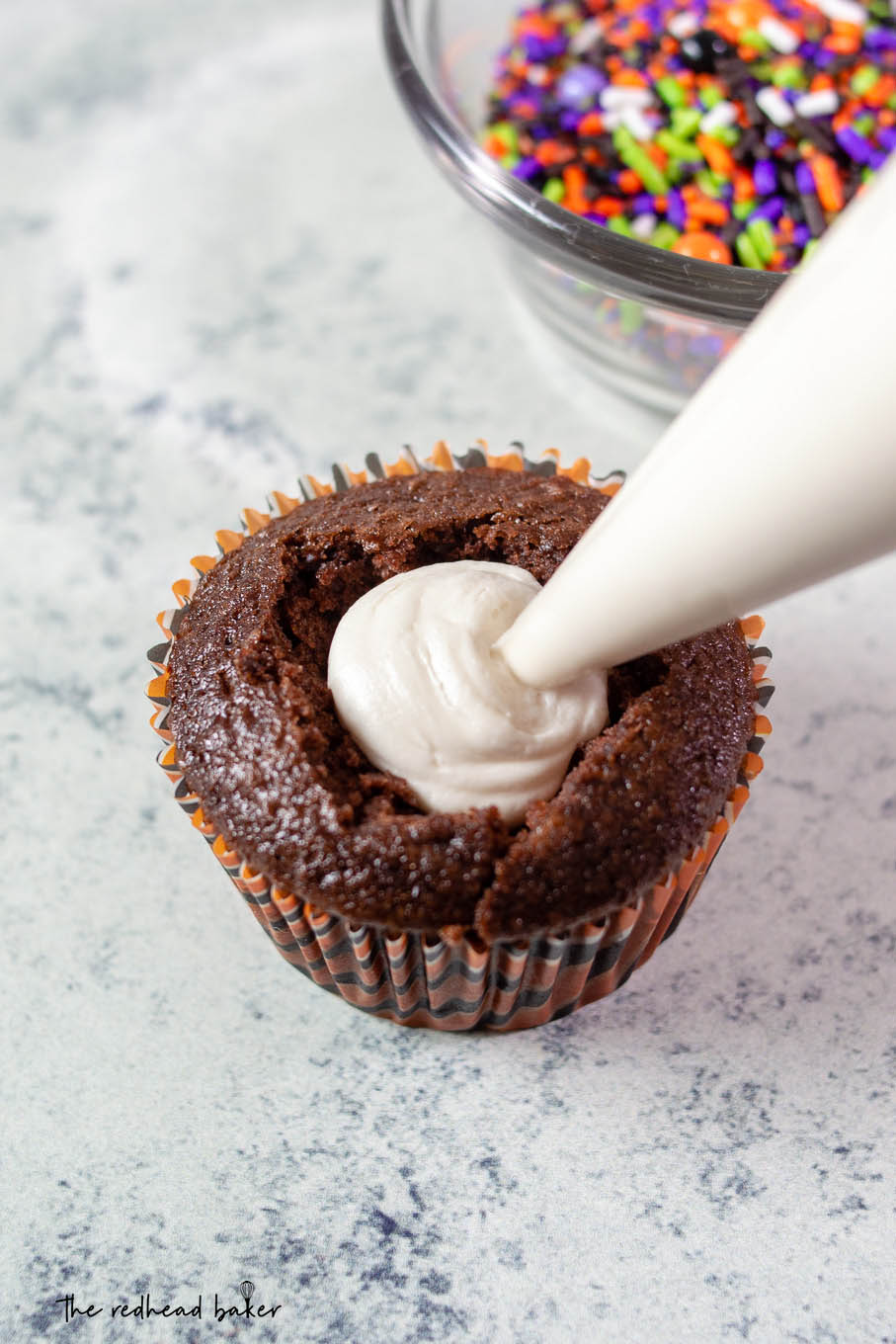 Marshmallow filling being piped into a cauldron cake