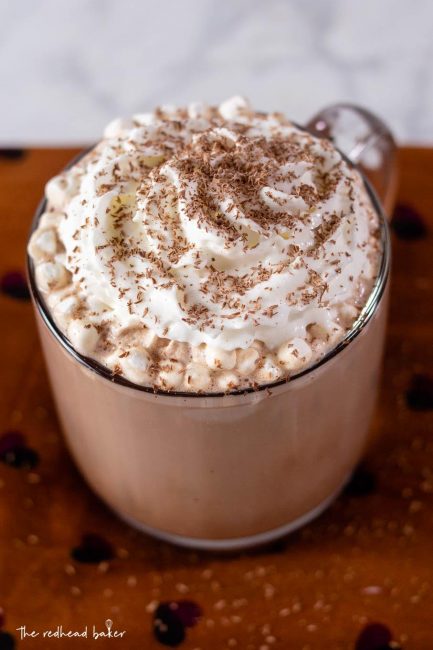 A mug of creamy hot chocolate topped with whipped cream and grated chocolate