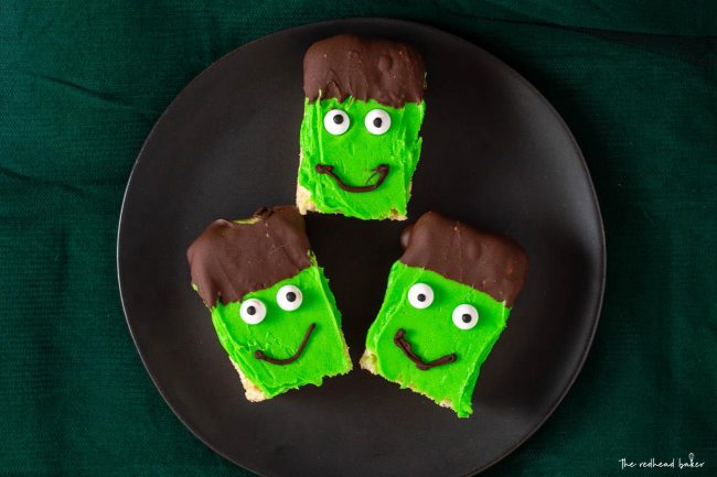 Overhead shot of three Frankenstein Crispy Cereal Treats on a black plate