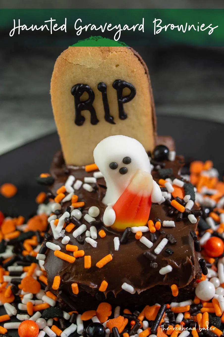 A close-up of a haunted graveyard brownie with orange, black and white sprinkles on a black plate