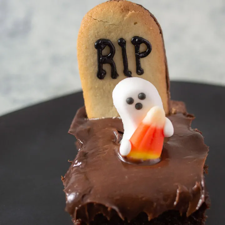 A close-up of a haunted graveyard brownie on a black plate