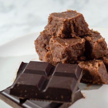 A pyramid of old-fashioned chocolate fudge next to unwrapped squares of Divine Chocolate 100% unsweetened baking chocolate