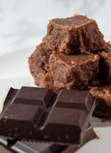 A pyramid of old-fashioned chocolate fudge next to unwrapped squares of Divine Chocolate 100% unsweetened baking chocolate