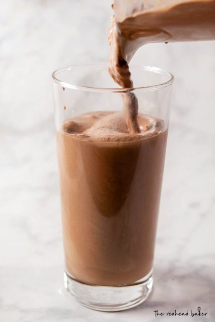 Triple chocolate malt milkshake being poured into a glass