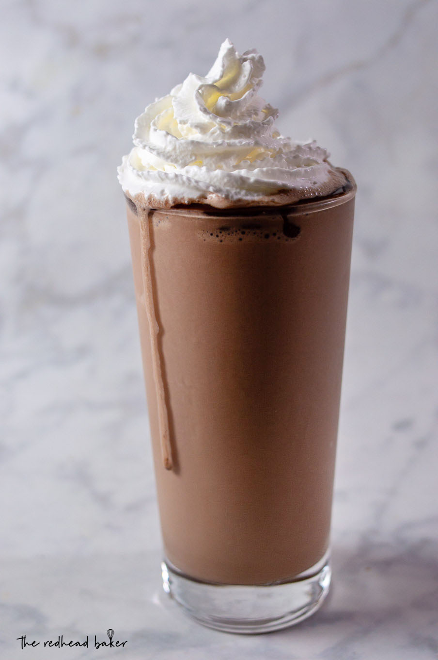 A triple chocolate malt milkshake garnished with whipped cream