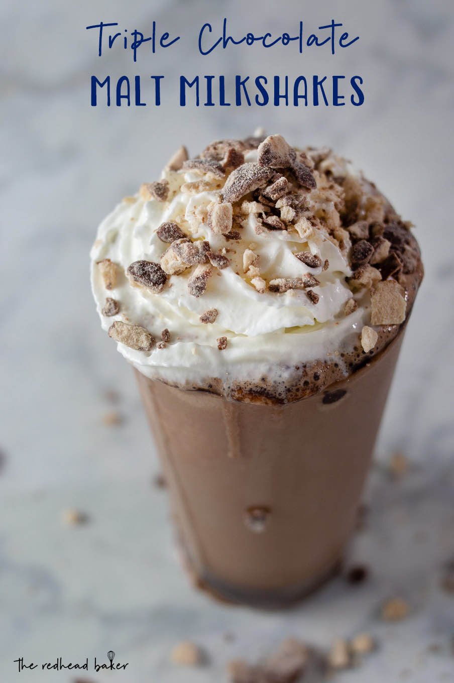 A triple chocolate malt milkshake garnished with whipped cream and crushed malted milk candies