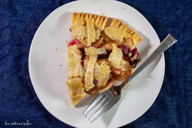 An overhead shot of a slice of cranberry apple pie