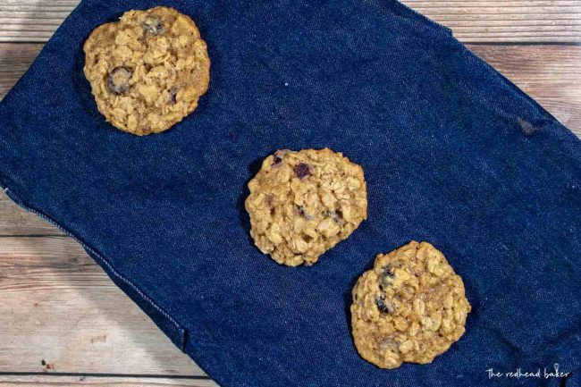 Three cranberry-orange oatmeal cookies on a blue placemat