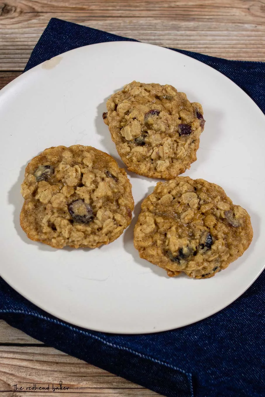 Three cranberry-orange oatmeal cookies on a plate