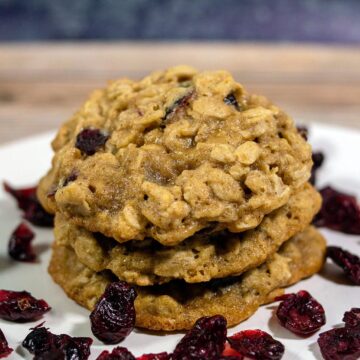 Three cranberry-orange oatmeal cookies in a stack