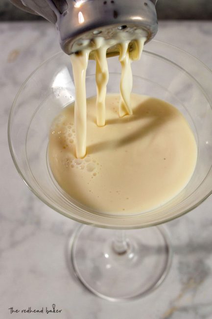 White chocolate eggnog martini being poured into a cocktail glass