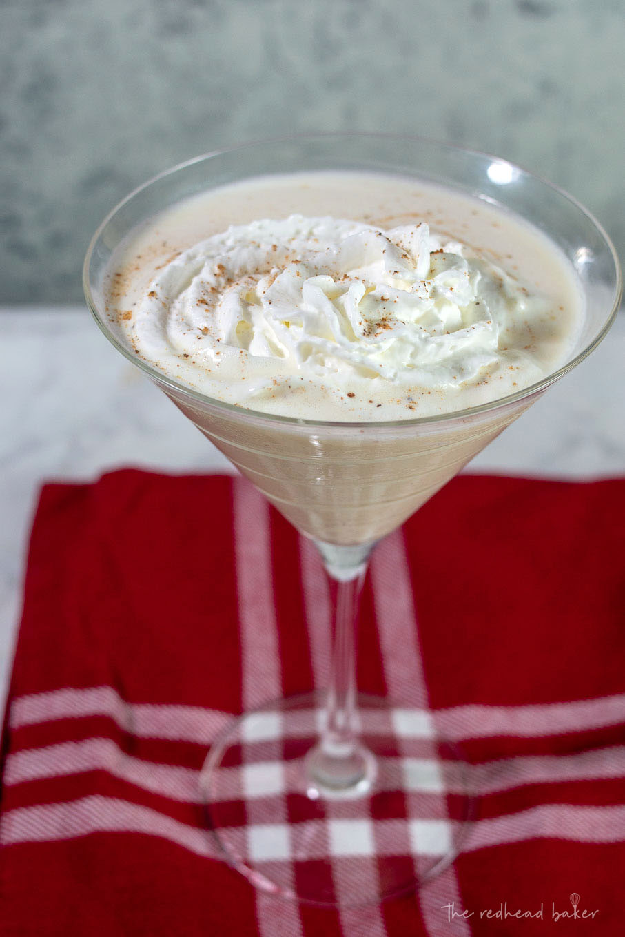 A white chocolate eggnog martini on a red placemat