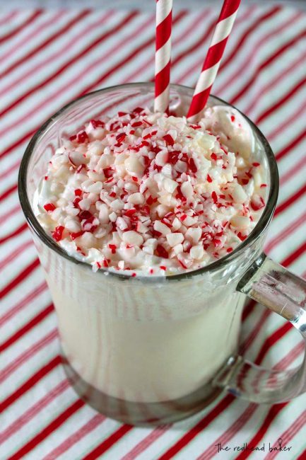 A down-angle shot of a candy cane crunch milkshake garnished with whipped cream and crushed candy canes