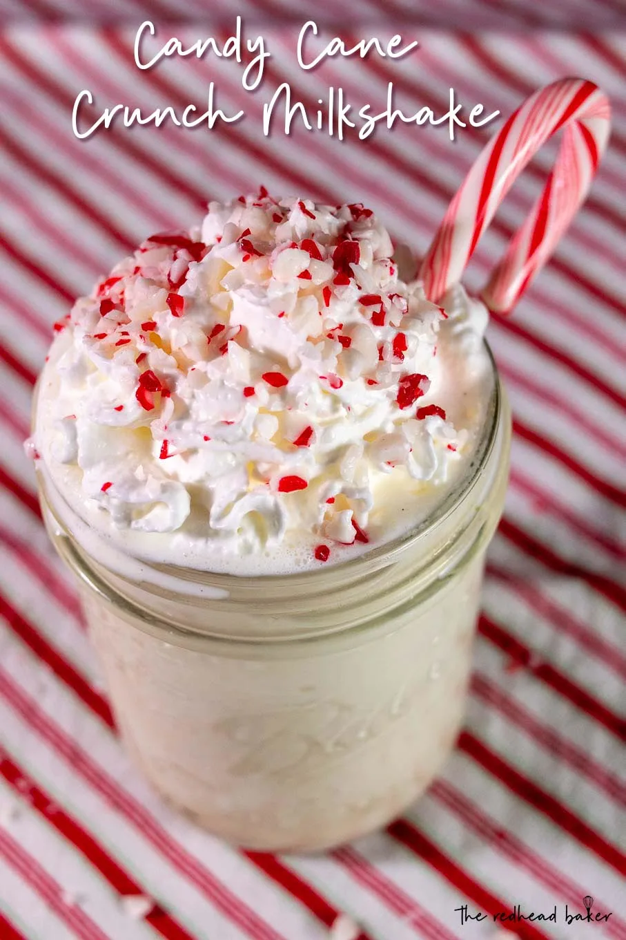 A candy cane crunch martini garnished with whipped cream, crushed candy canes and one whole candy cane
