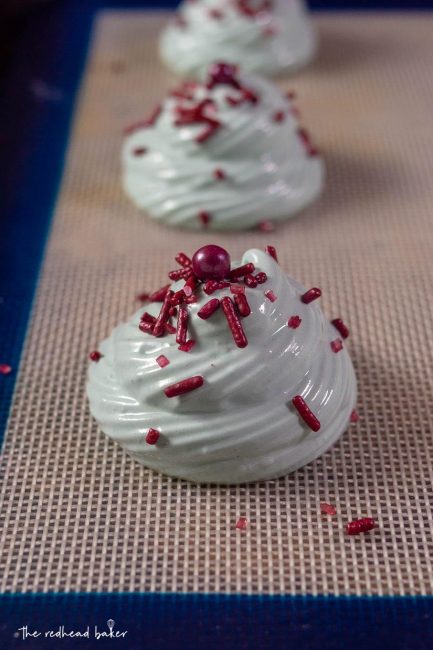 Unbaked meringue cookies on a silicone baking mat