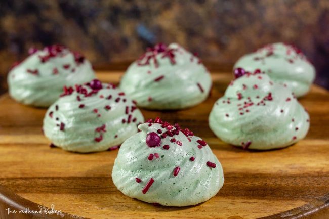 Six meringue cookies on a wooden board