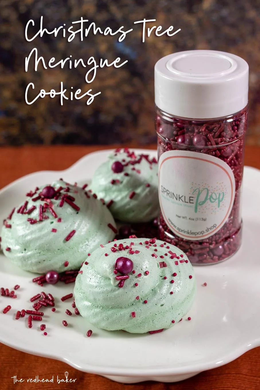 Three meringue cookies next to a bottle of Sprinkle Pop sprinkle mix