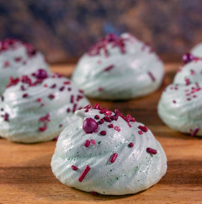 Six meringue cookies on a wooden bardo