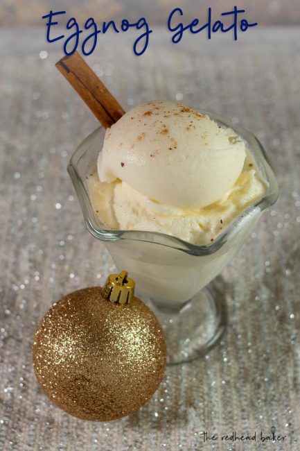 A dish of eggnog gelato with a cinnamon stick, and a glittery gold ornament in front of the dish