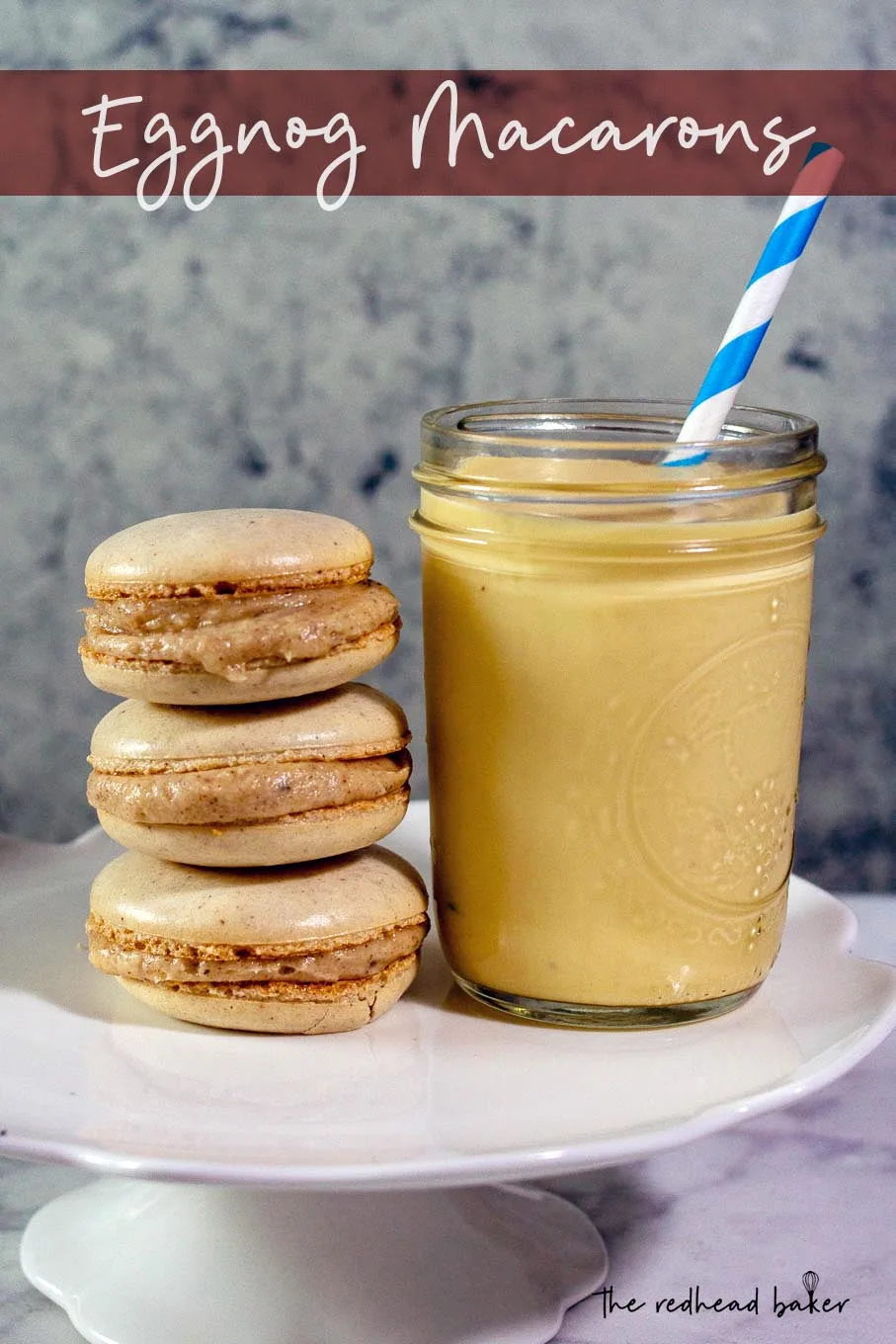 Three eggnog macarons stacked next to a mason jar of eggnog