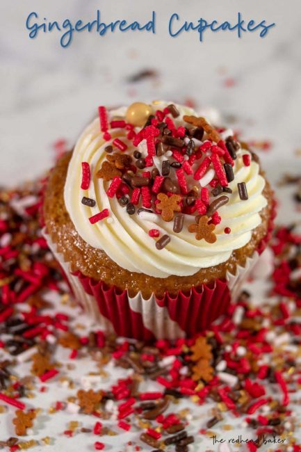 A gingerbread cupcake with cream cheese frosting amid a layer of Sweets and Treats gingerbread sprinkles