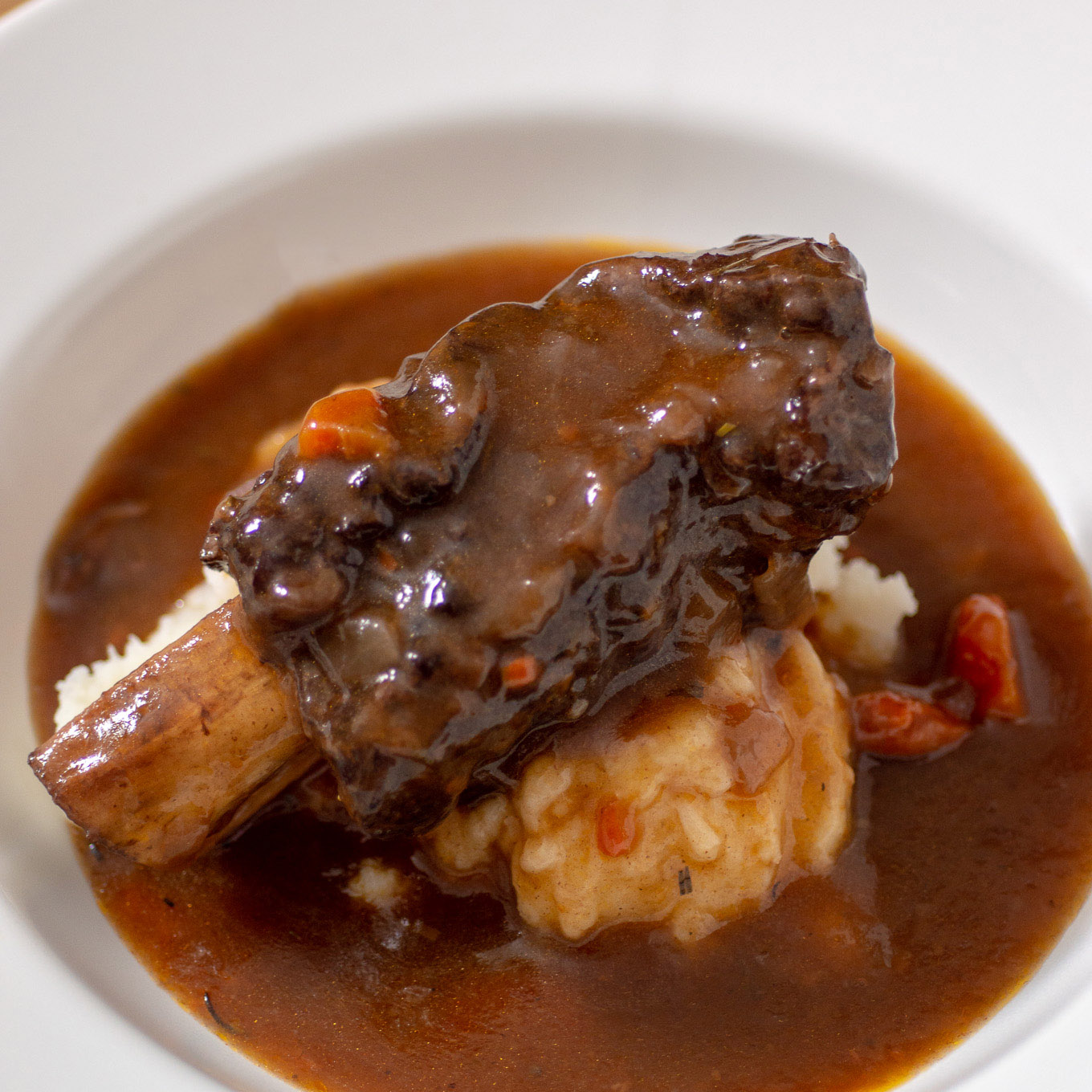 A short rib on the bone over mashed potatoes with gravy.
