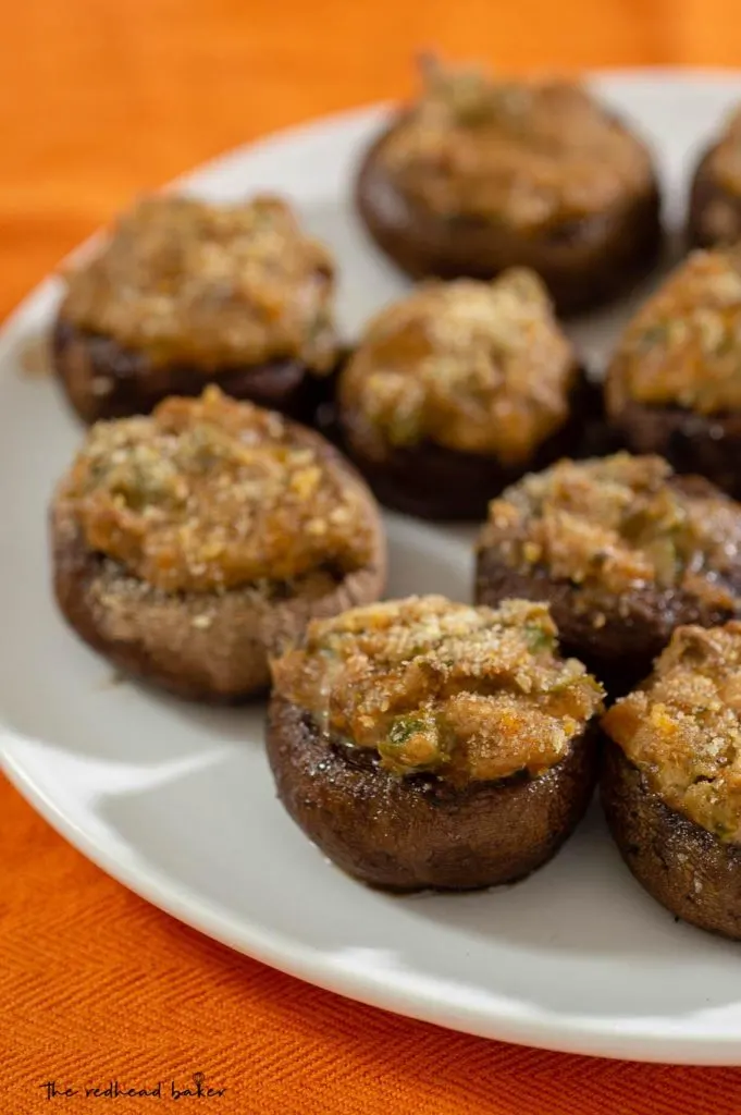 A plate of jalapeno popper stuffed mushrooms on an orange placemat.