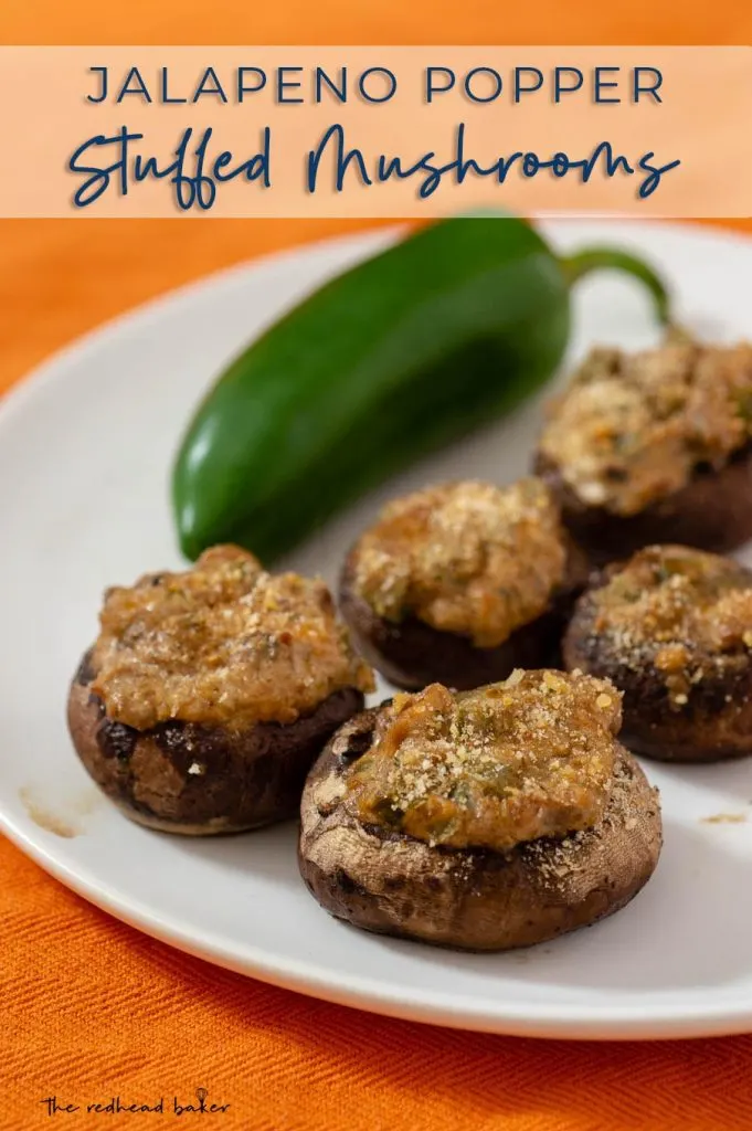 A plate of jalapeno-popper stuffed mushrooms, with a whole jalapeno pepper in the background