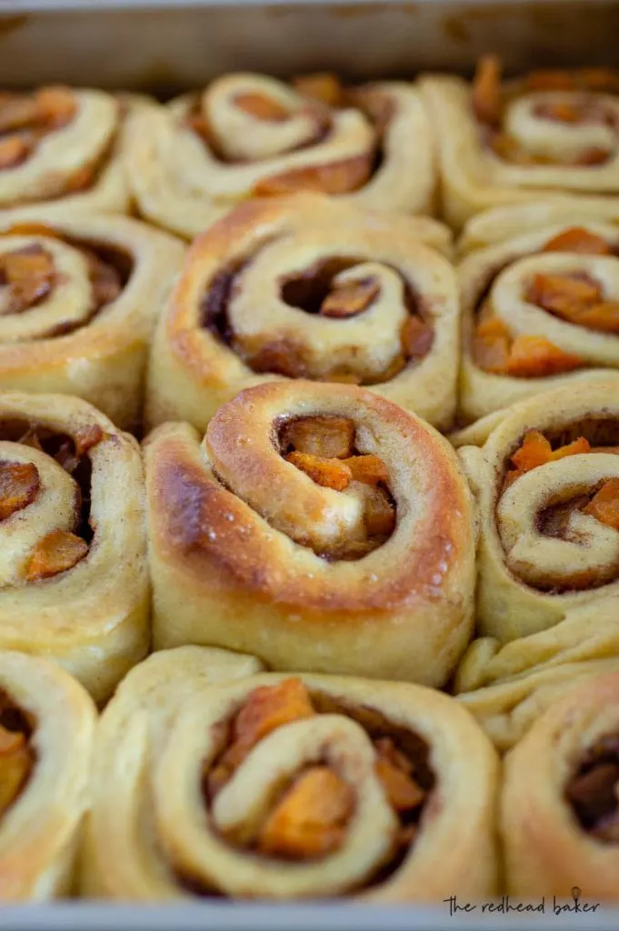 A baking pan of unglazed salted caramel peach sweet rolls