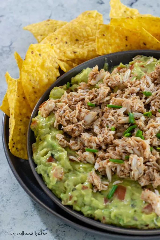 A plate of spicy crab guacamole surrounded by tortilla chips