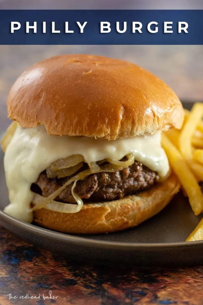 A Philly burger and fries on a matte black plate