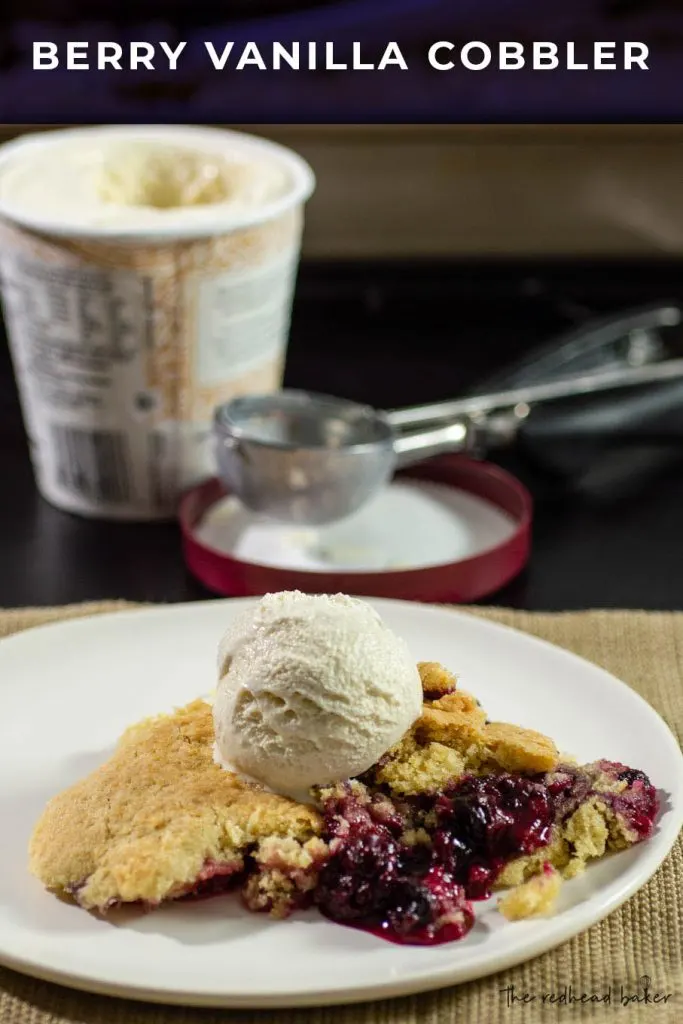 A plate of mixed berry cobbler with a scoop of ice cream in front of the open pint contianer of ice cream