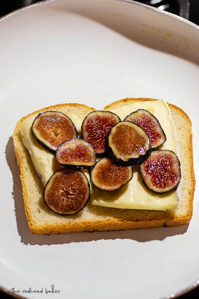 A slice of bread with brie and figs in a frying pan