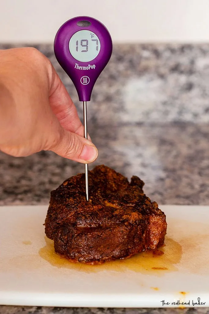 A ThermoPop thermometer in a cooked cut of pork shoulder