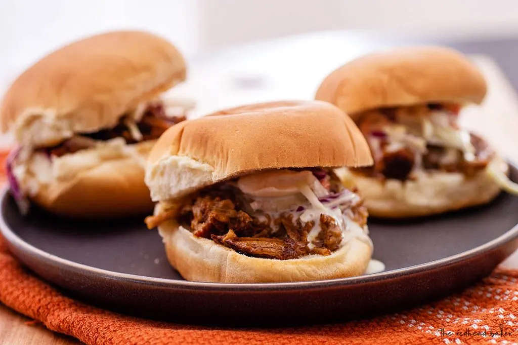 Three pulled pork sliders on a plate