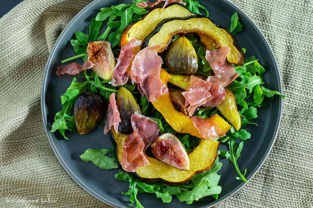 A close-up view of a plate of roasted acorn squash and fig salad